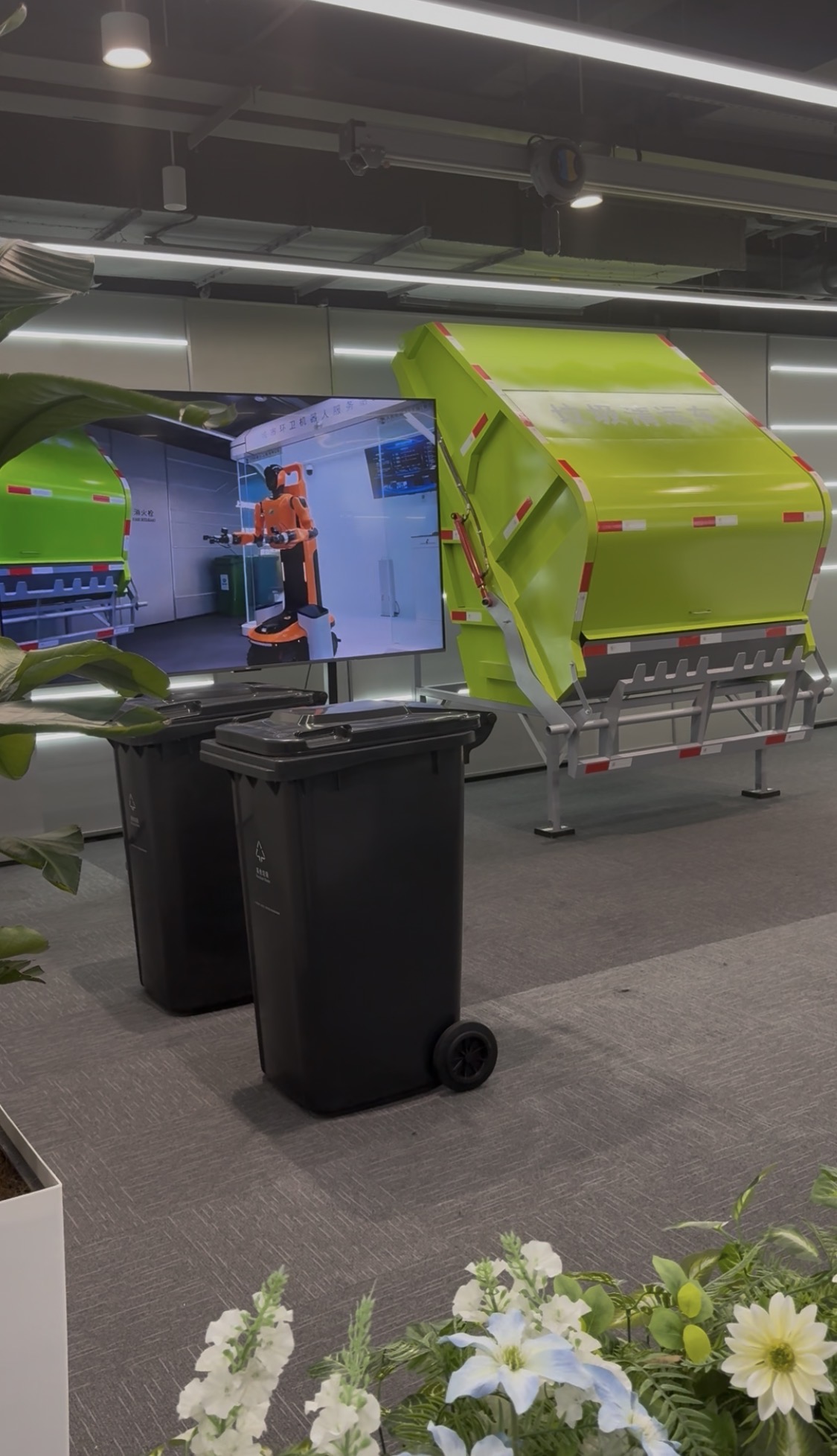 Présentation d'un équipement de collecte avec des bacs et un écran montrant un robot mobile