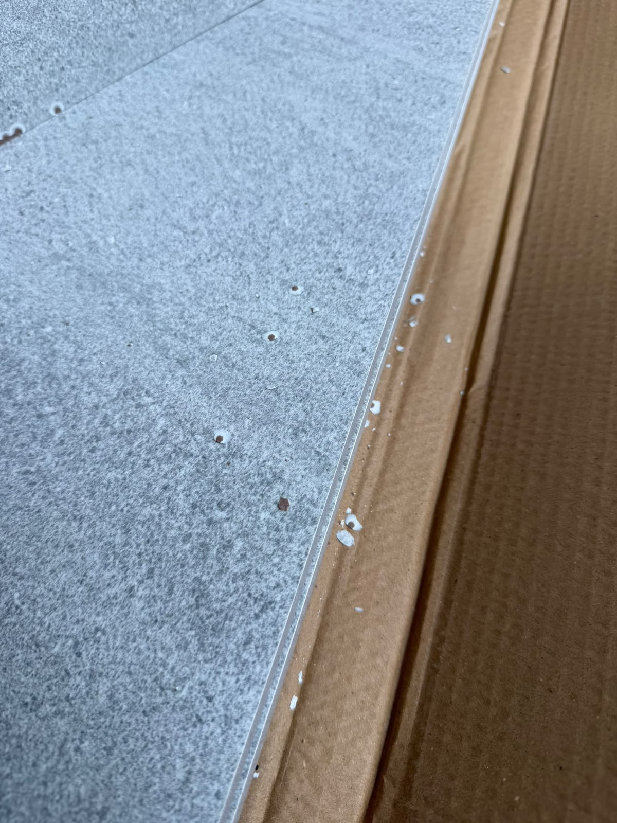 Carreaux de carrelage présentant de petits éclats et impacts en surface et sur les arêtes
