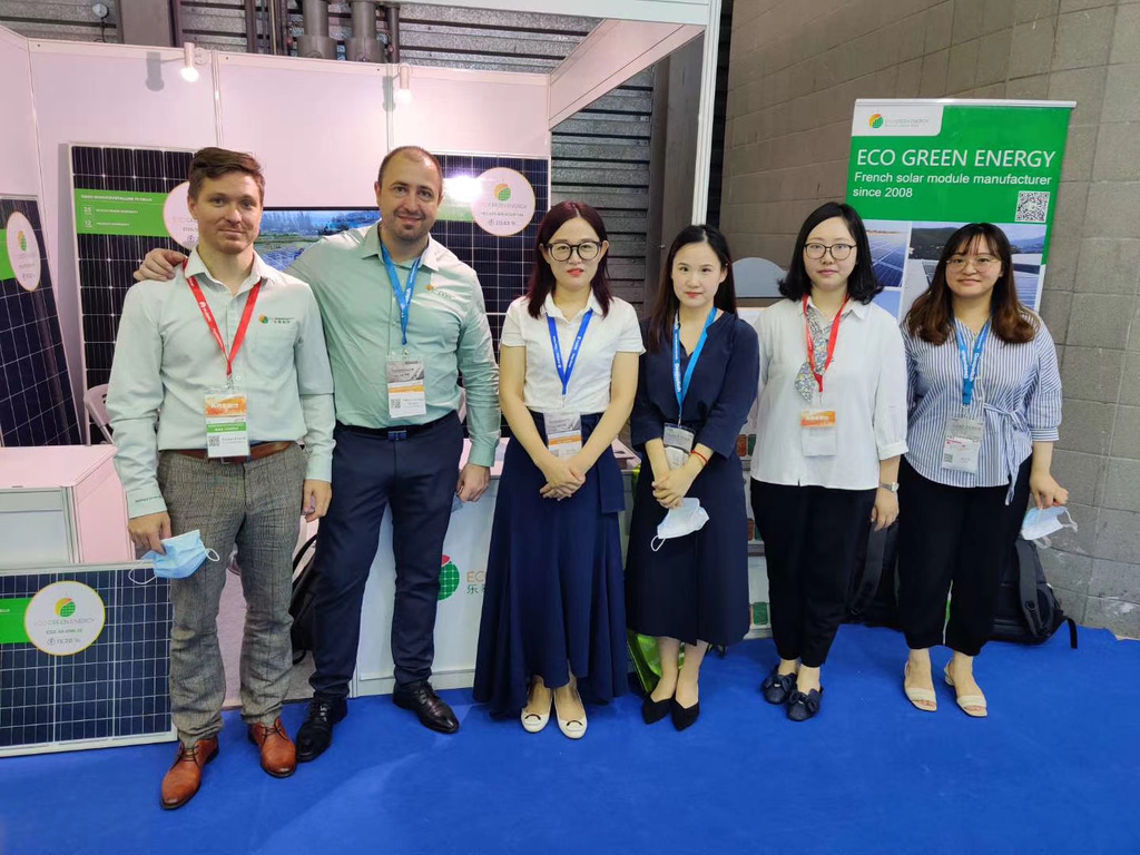 Équipe sur un salon industriel en Chine devant des panneaux solaires